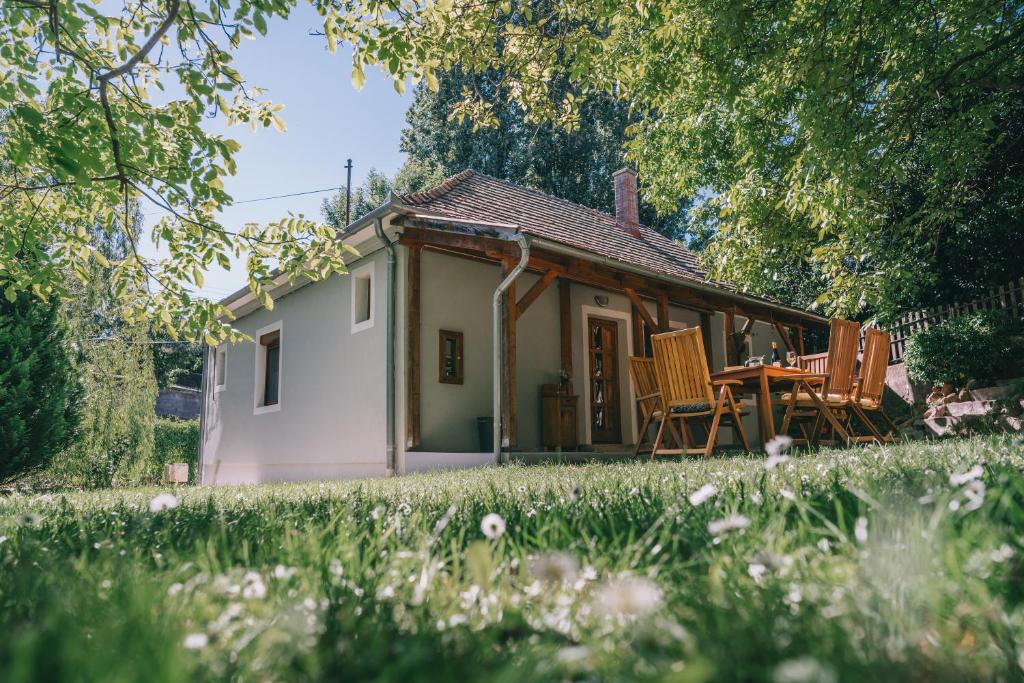 Cabaña pequeña con mesa y sillas en un patio en Róka Porta en Szentkirályszabadja