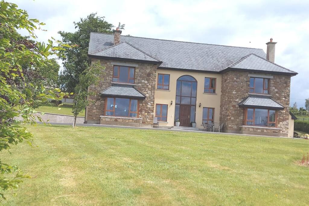 una casa grande con un gran patio delante en The Attic en Kilkenny