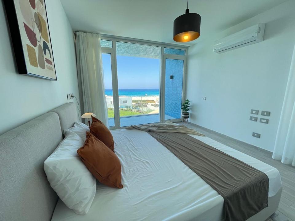 a bedroom with a large bed and a large window at Villa Sea View in Fouka Bay North Coast with pool in Marsa Matruh
