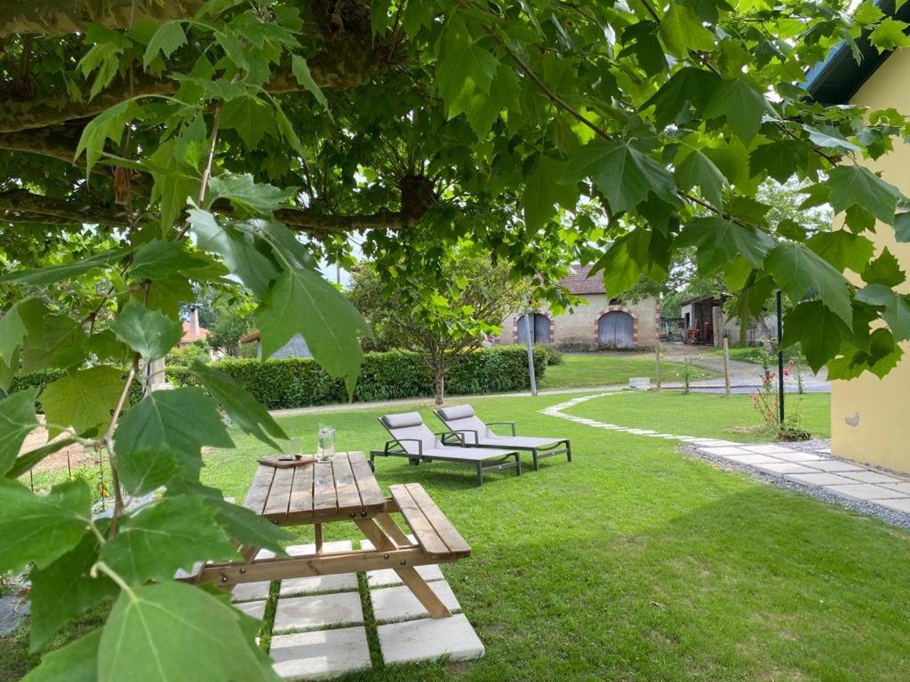 stół piknikowy i dwie ławki w parku w obiekcie Le Grand Marguit*** sur la Côte Basco-Landaise w mieście Tarnos