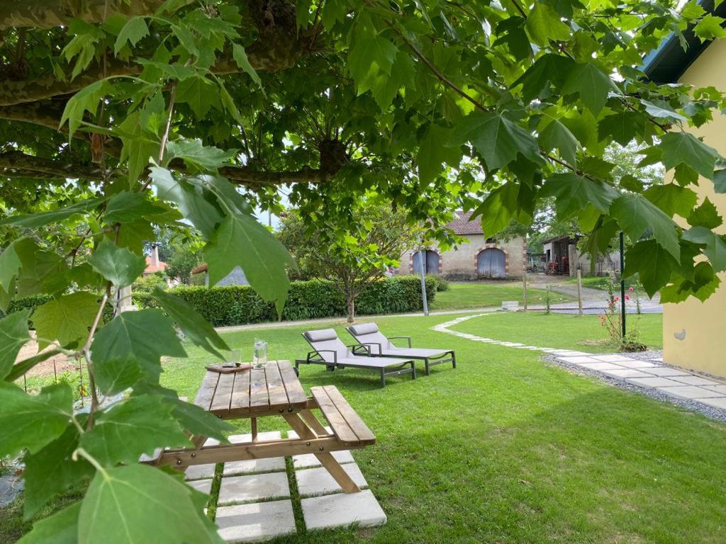 a picnic table and two benches in a park at Le Grand Marguit*** sur la Côte Basco-Landaise in Tarnos