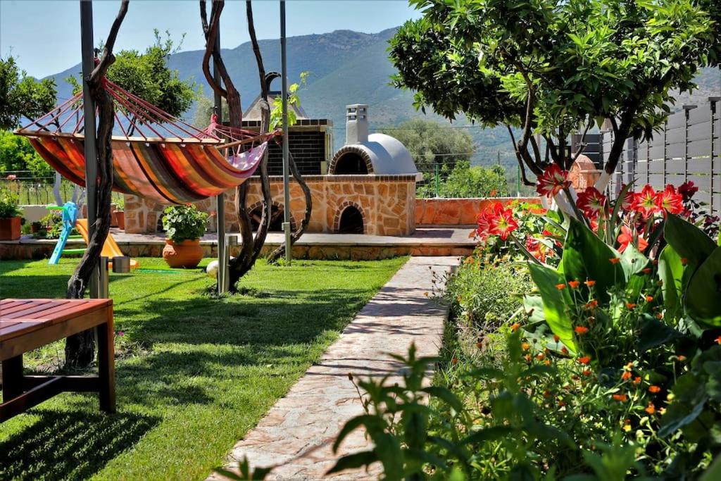 a garden with a hammock and some flowers and a building at "Elegant & Quiet House" in Igoumenitsa