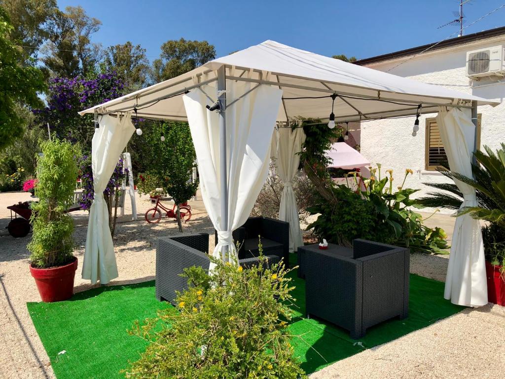 a white canopy on a lawn with plants at Villa Cenzina in Marina di Pisticci