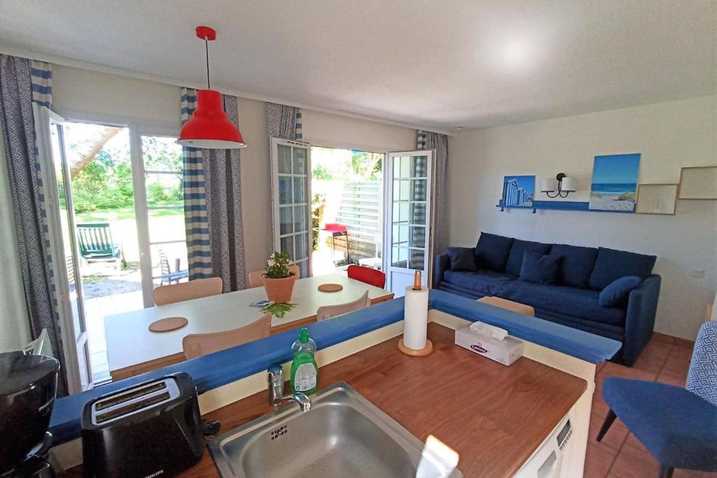 a living room with a blue couch and a table at Bright 50 M For 6 With Balcony And Garden in Moliets-et-Maa