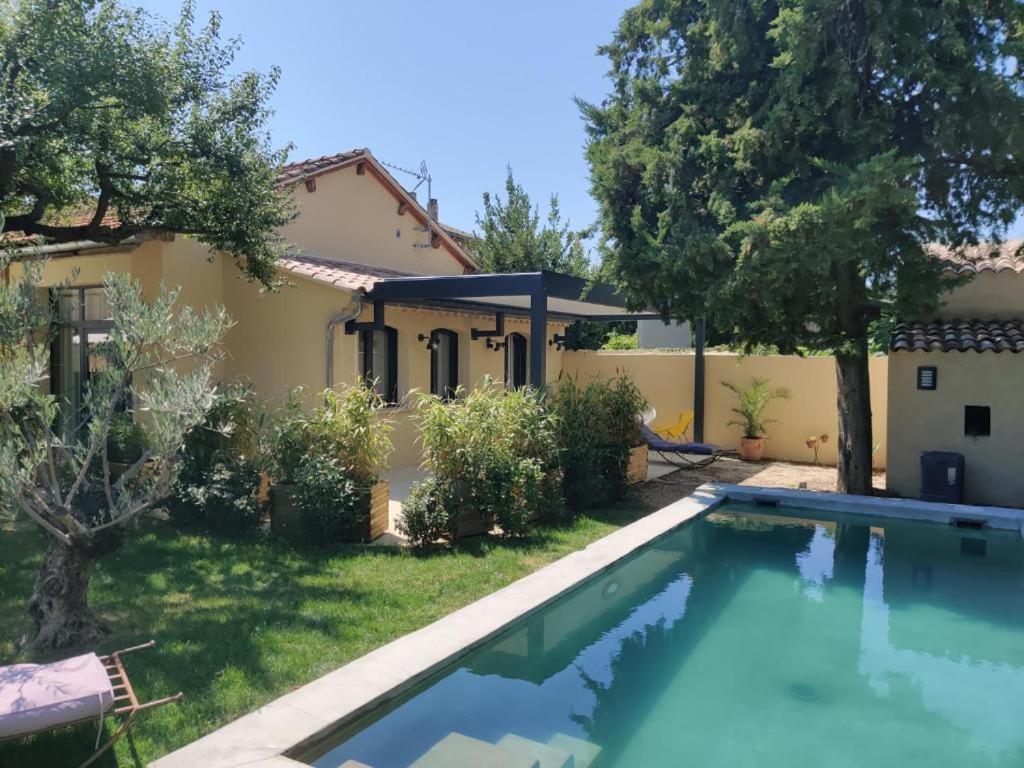 a villa with a swimming pool in front of a house at Gîte Pavillon Flavia in Vaison-la-Romaine