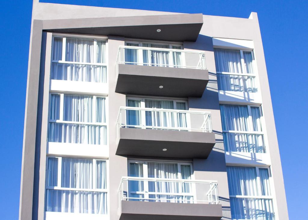 un edificio de apartamentos alto con balcones. en CQ MITRE en Puerto Madryn