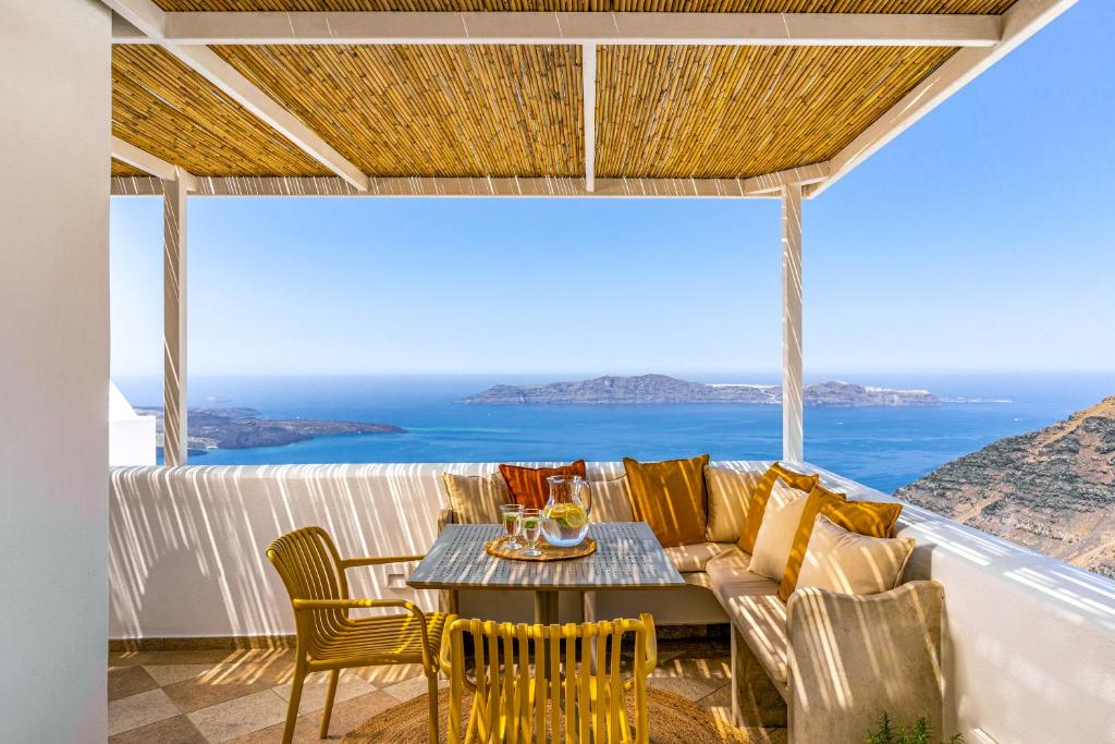 a living room with a couch and a table and chairs at Vacay Suites in Firostefani