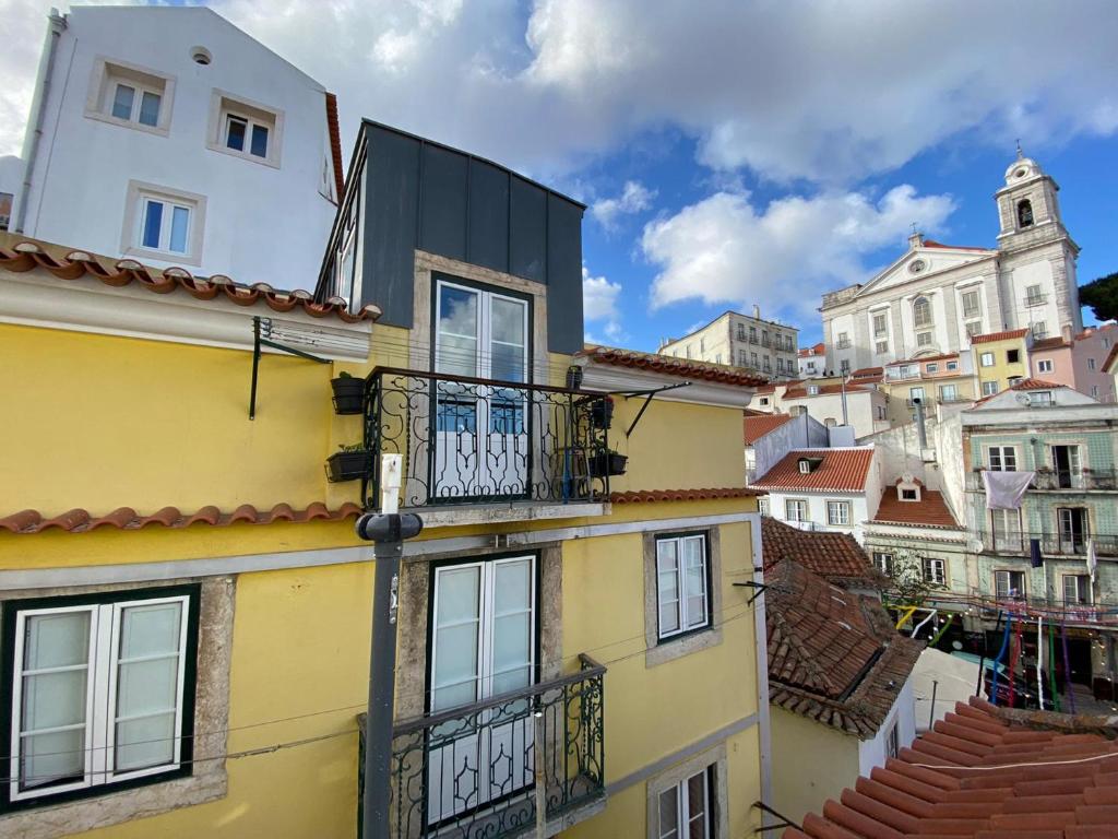 リスボンにあるAlfama Cozy Loftのバルコニーと屋根付きの建物