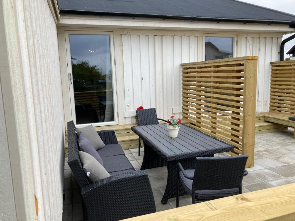 eine Terrasse mit einem Tisch und Stühlen auf einer Terrasse in der Unterkunft Gustavsro i Apelviken Annex 2 in Varberg