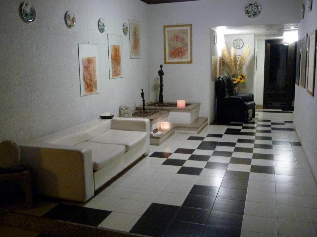a living room with a couch and a checkered floor at B&B Cà d'Artisti in Caorle