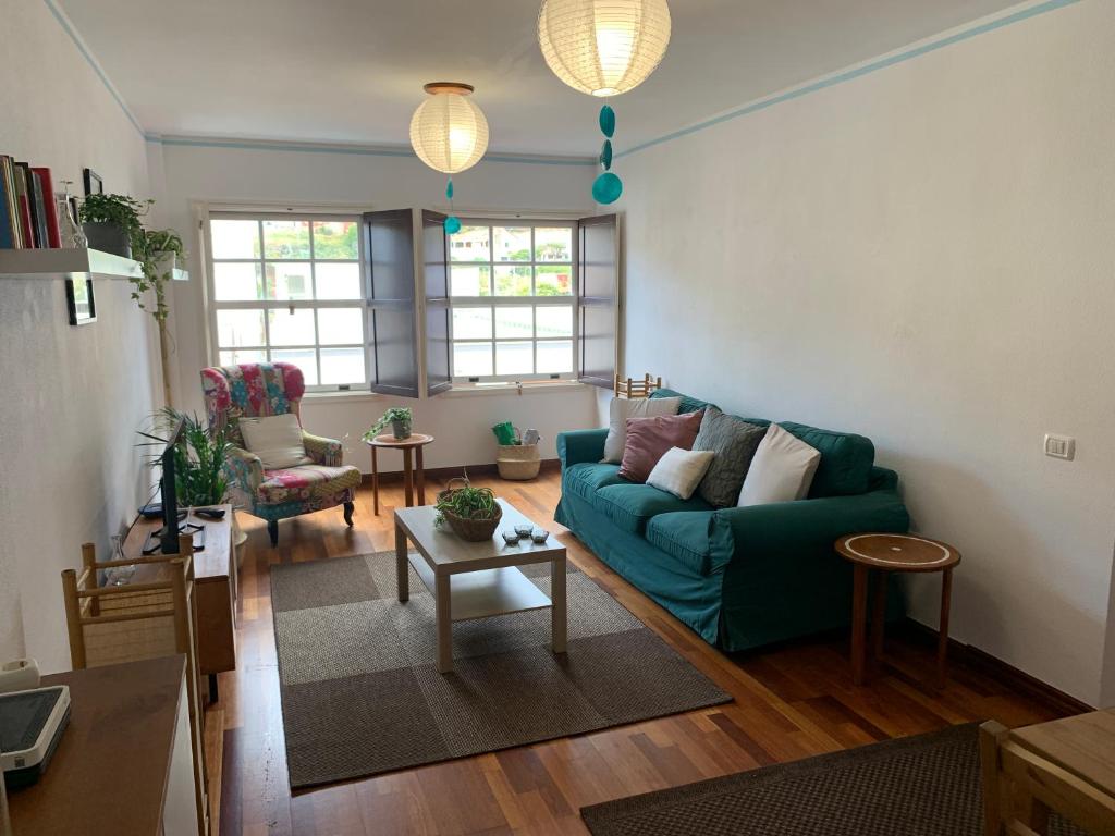 a living room with a green couch and a table at La Casita de mi Alma - Das Haus meiner Seele (Tegueste) in Tegueste