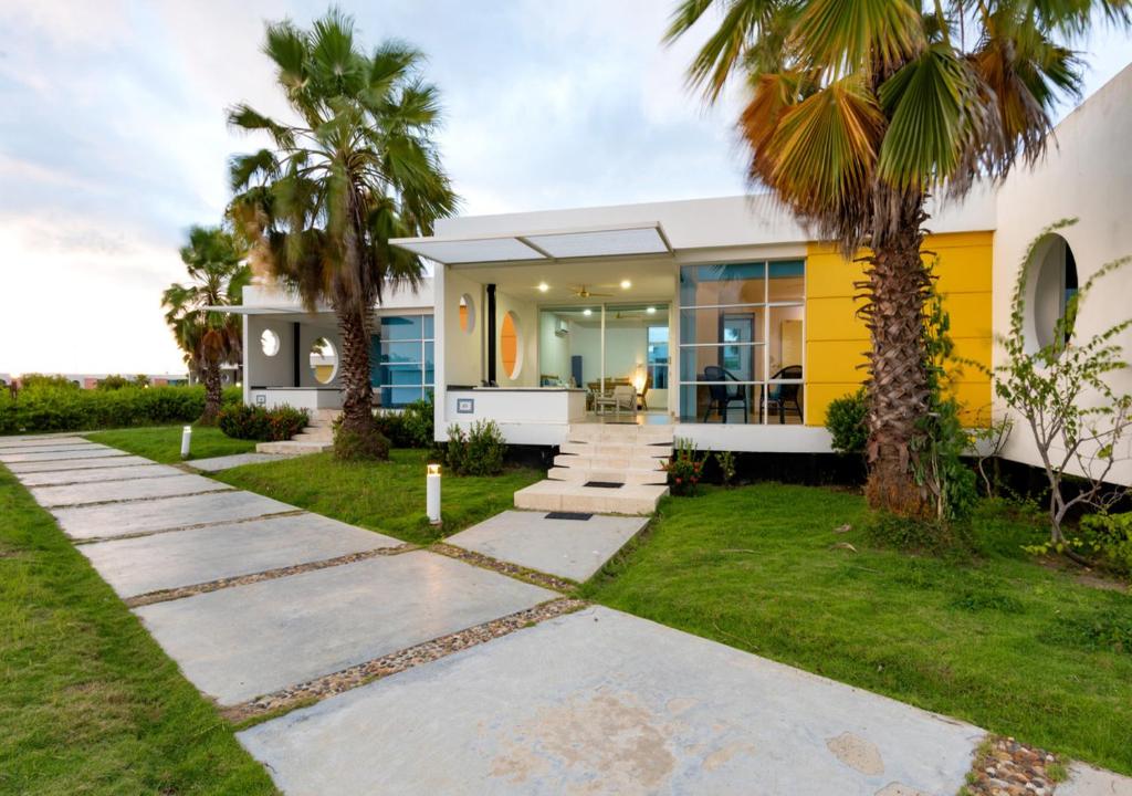 a home with palm trees in the yard at Marina Puerto Velero in Tubará