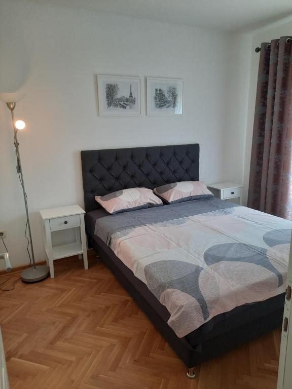 ein Schlafzimmer mit einem Bett und einer Lampe in der Unterkunft Apartman NK in Nikšić