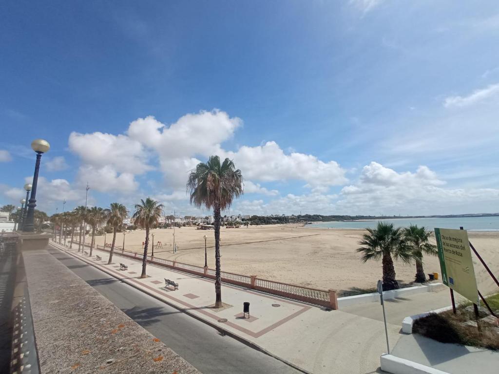 una playa de arena con palmeras y el océano en Casa Reyes, en Rota