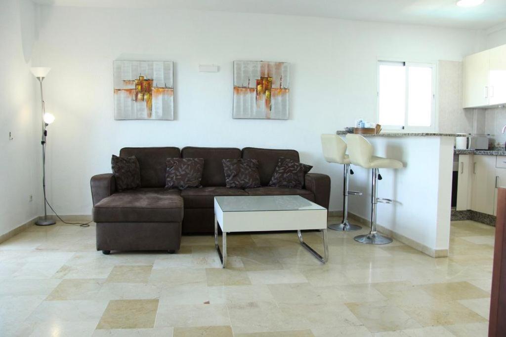 salon z brązową kanapą i stołem w obiekcie Apartamento Rio Mar w Marbelli