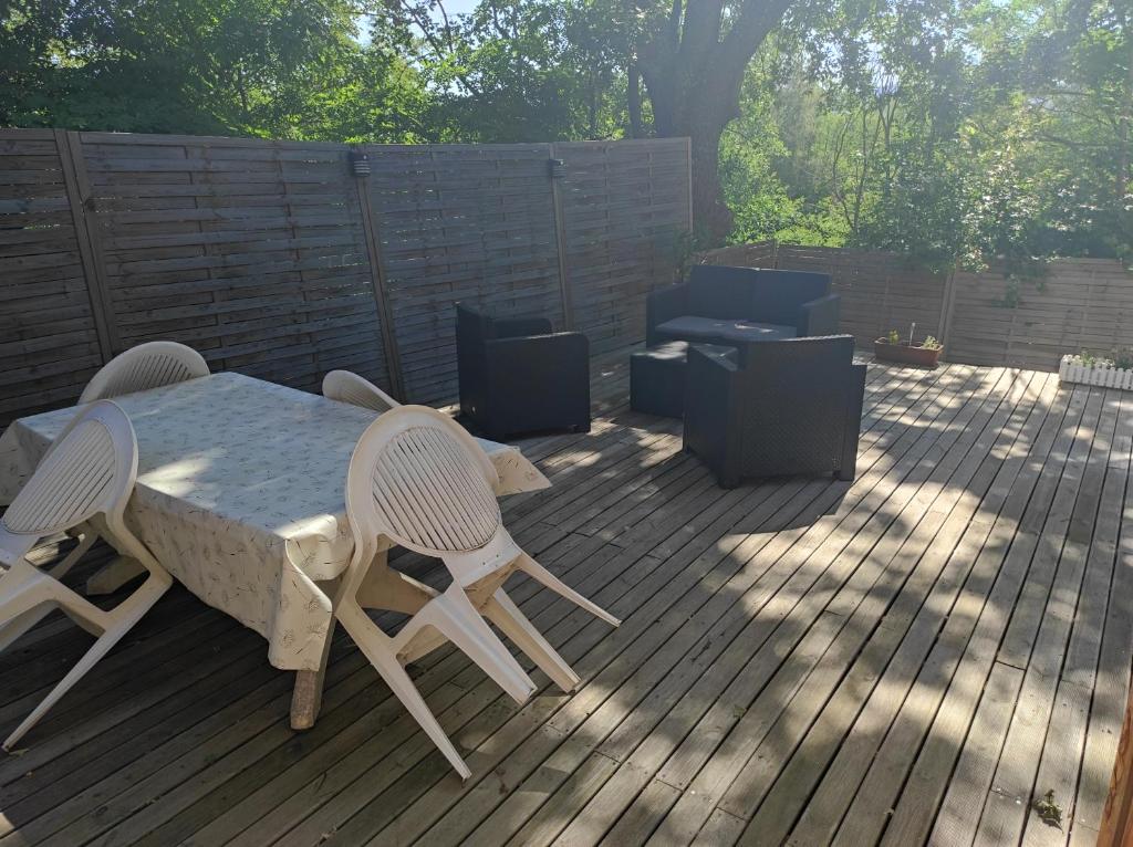 a patio with a table and chairs on a deck at Apartement 'les lavandes" RdC 2CH - terrasse et parking à Lurs in Lurs
