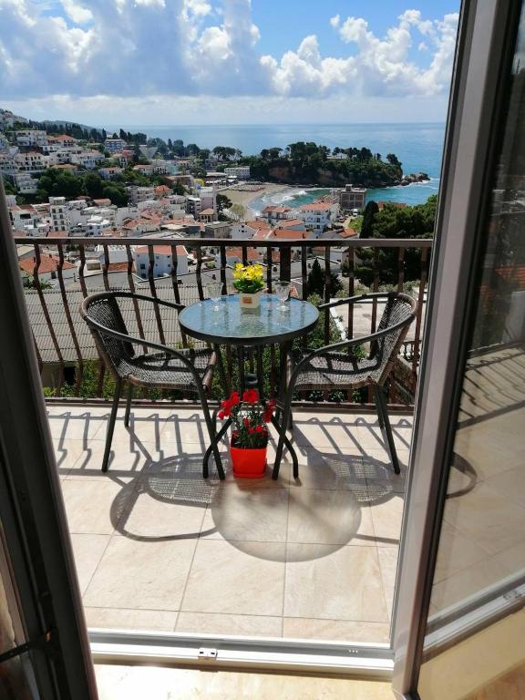 a table on a balcony with a view of the ocean at Apartment Olimp Ulcinj in Ulcinj