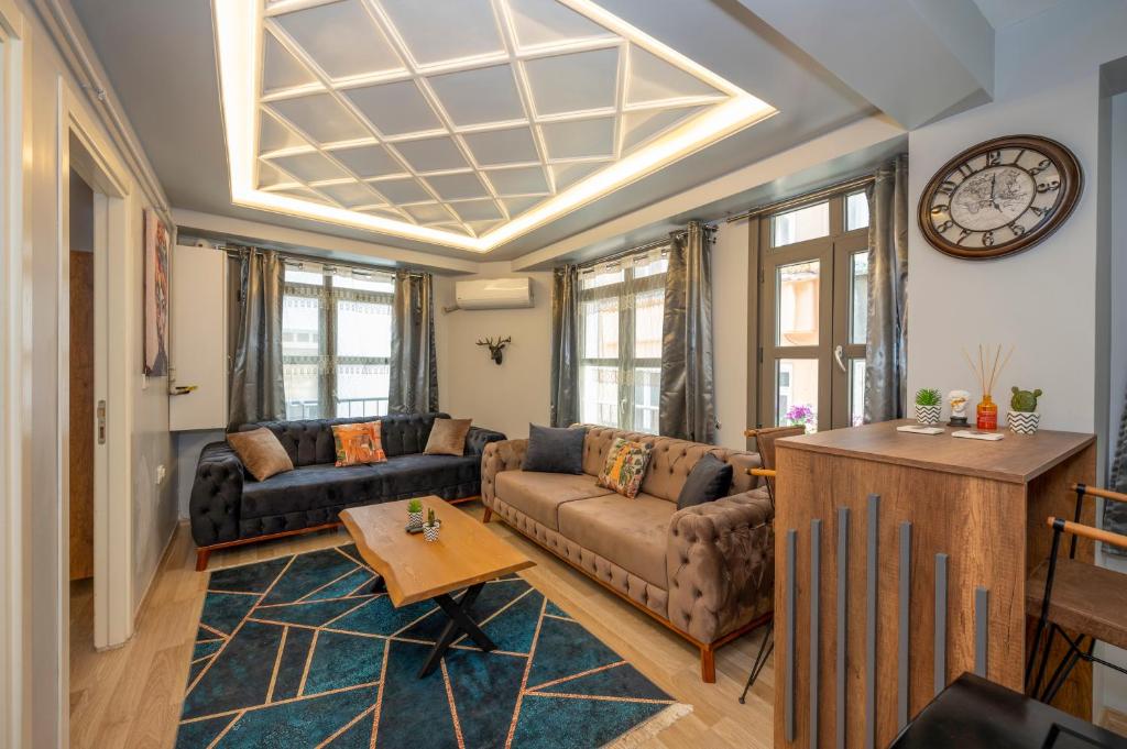 ein Wohnzimmer mit einem Sofa und einer Uhr an der Wand in der Unterkunft Dorne Suite Taksim Hotel in Istanbul