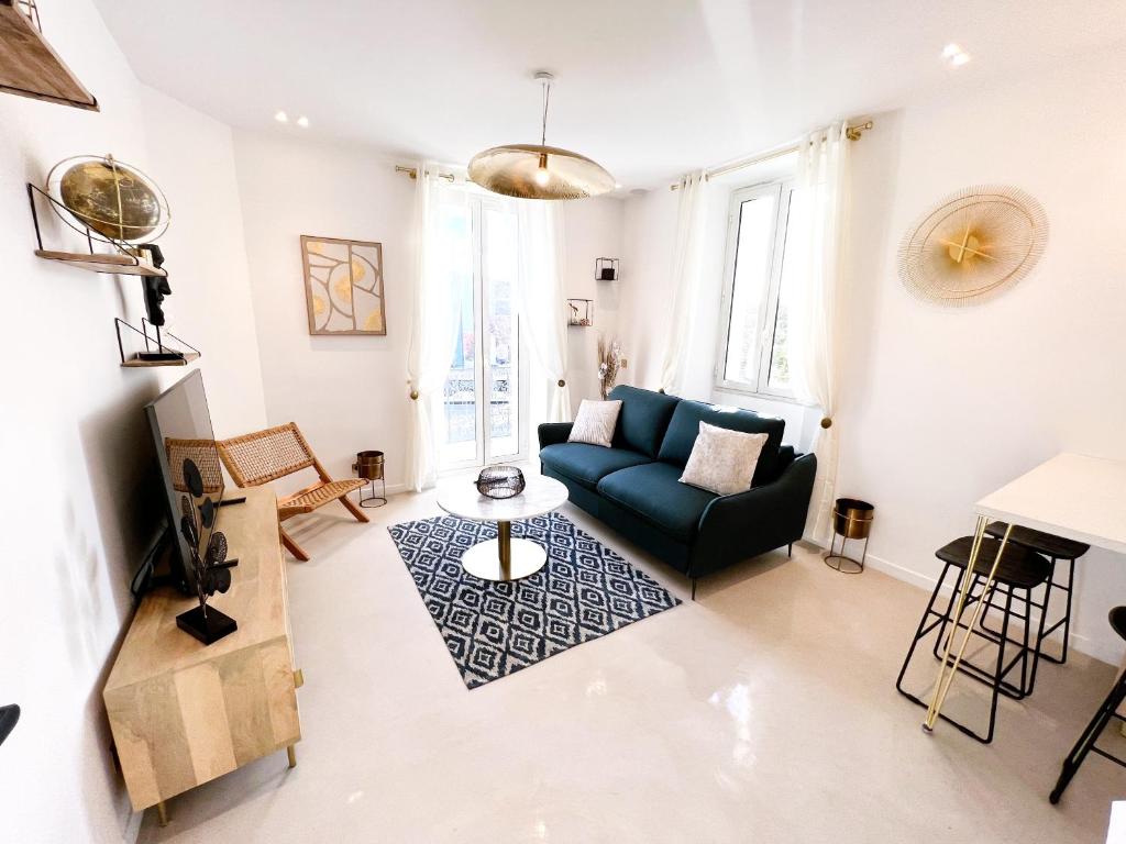 a living room with a blue couch and a table at La LOLA APARTMENT in Cannes