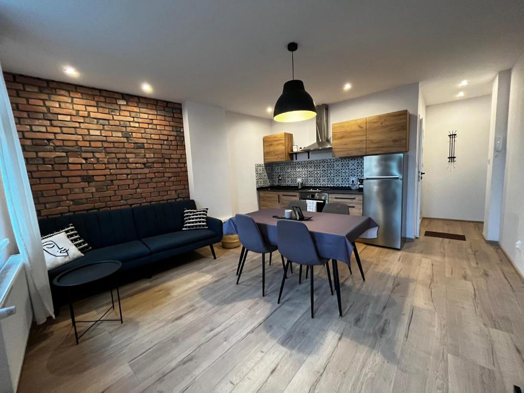 a living room and kitchen with a couch and a table at Central Apartment in Bydgoszcz