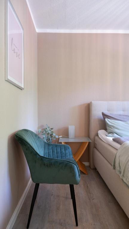 einen grünen Stuhl in einem Zimmer mit einem Sofa in der Unterkunft Stylisches Apartment mit Balkon / Netflix / WIFI in Chemnitz