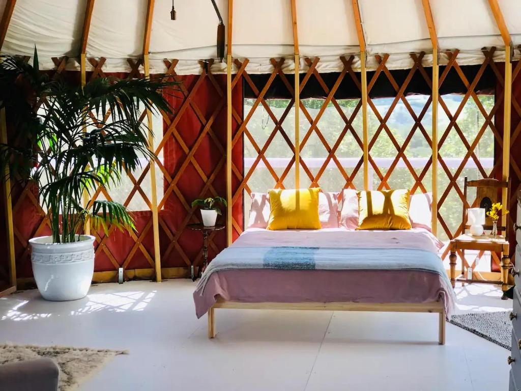 um quarto com uma cama numa tenda em Byron Bay Hinterland Eco-Retreat Terracota Yurt em Eureka