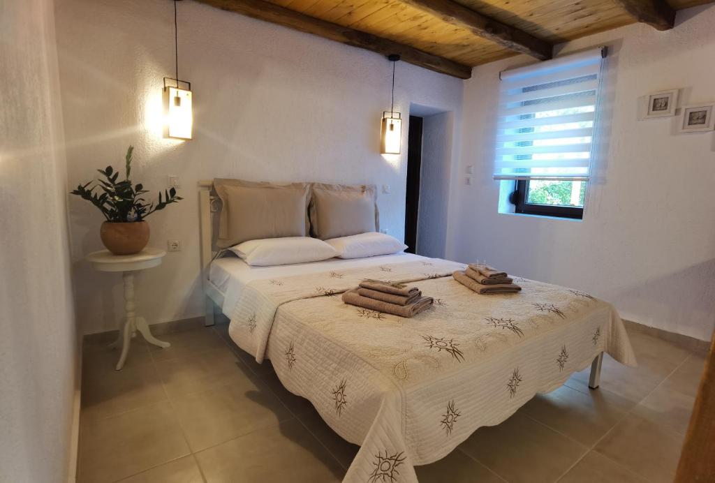 1 dormitorio con 1 cama con toallas en Elaion Thea-Nies, en Soúrpi