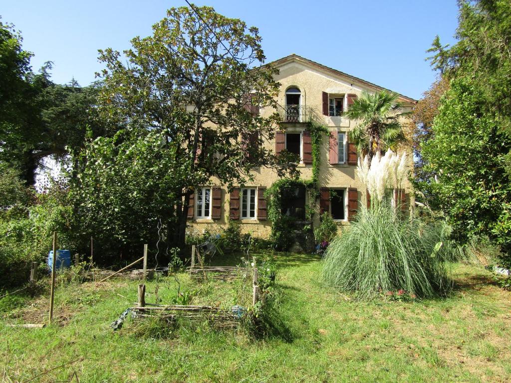 an old house with a garden in front of it at La Demeure des Fleurs in Caillavet