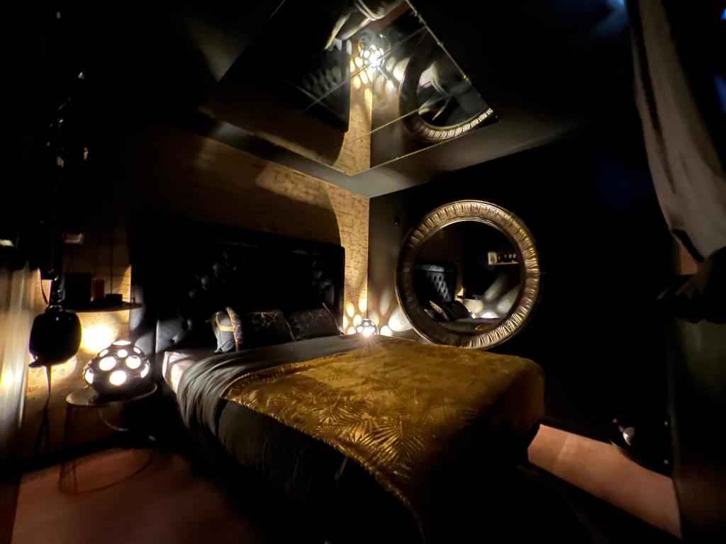 um quarto com uma cama grande e um espelho em La Suite Maléfik em Maing