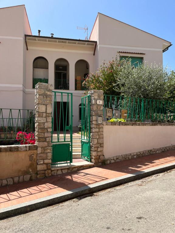 a house with a green gate in front of it at Bed and coffee Rooms Portoferraio in Portoferraio