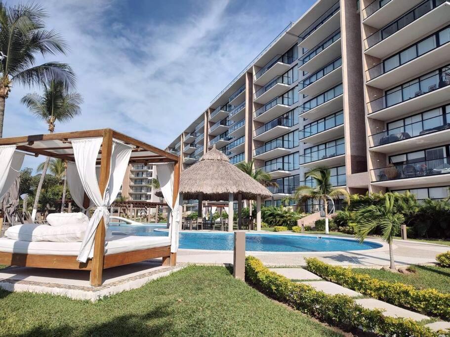 a bed and a gazebo next to a building at Altamar. Lugar perfecto para ser diamante in Acapulco
