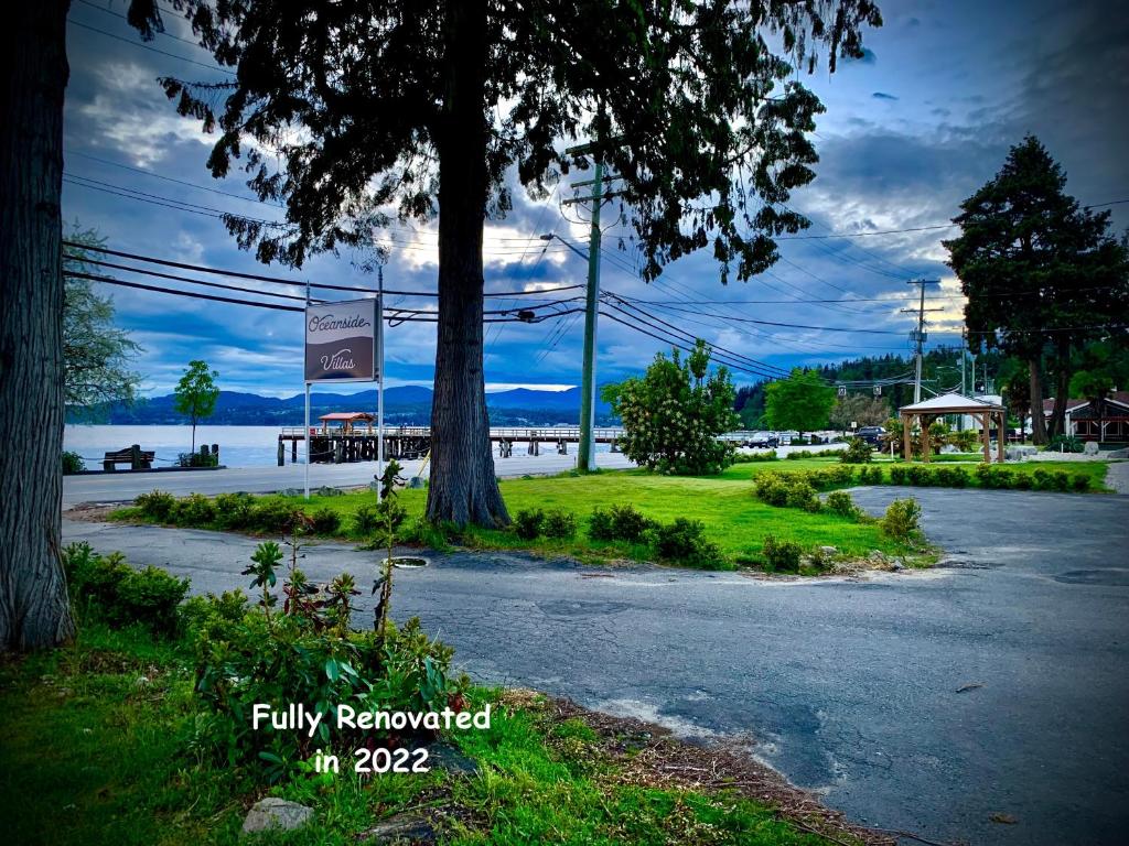 a street with trees and a body of water at Oceanside Villas in Sechelt