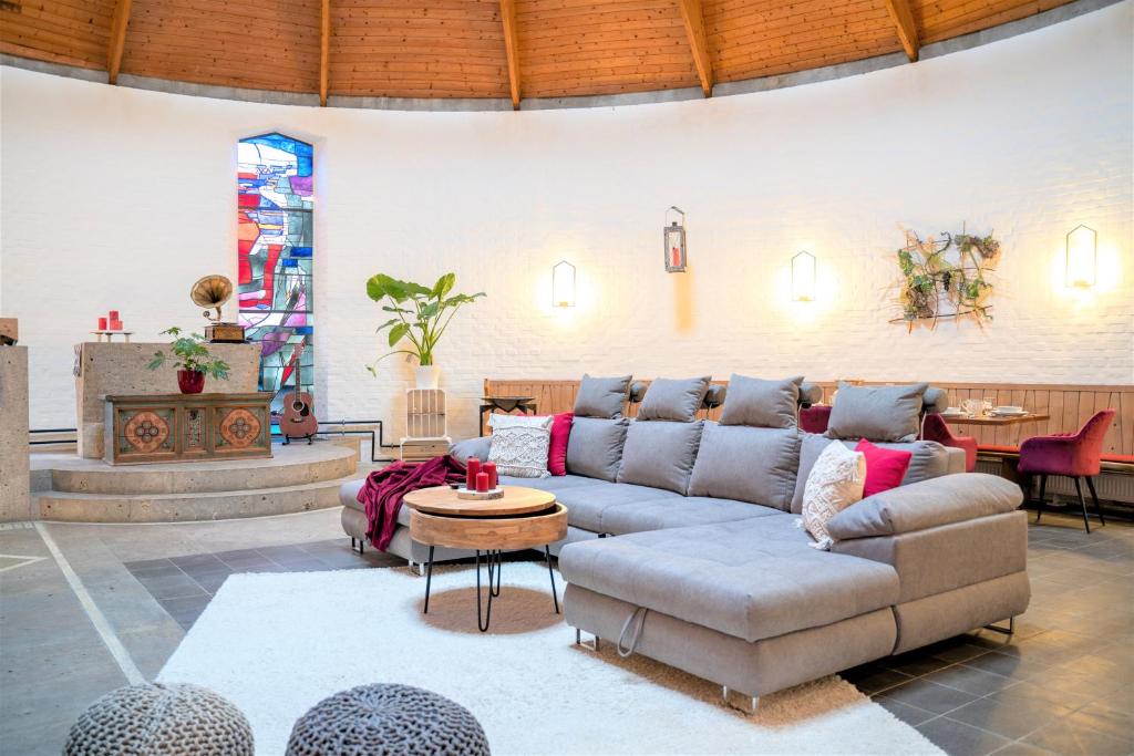 sala de estar con sofá y mesa en dreamcation - Wohnen in KIRCHE, 3D-Tour, Terrasse, BBQ, Küche, Kamin, 180qm en Kelheim