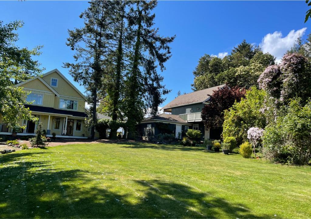 a house with a yard with green grass and trees at Quarrystone House B&B in Fernwood