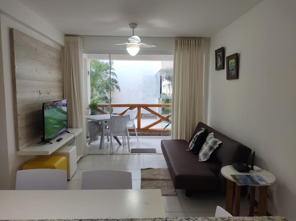 sala de estar con sofá y TV en Apartamento no Paraíso dos Corais, en Camaçari