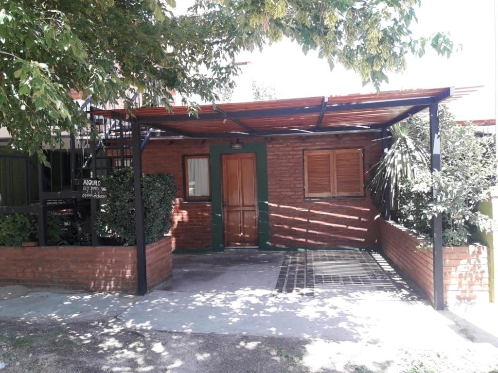 a brick house with awning in front of it at Ariel Reynoso - Departamento Planta Baja in Mina Clavero