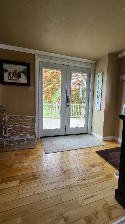an empty living room with doors and a wooden floor at Small Town Bound Inn in Montague