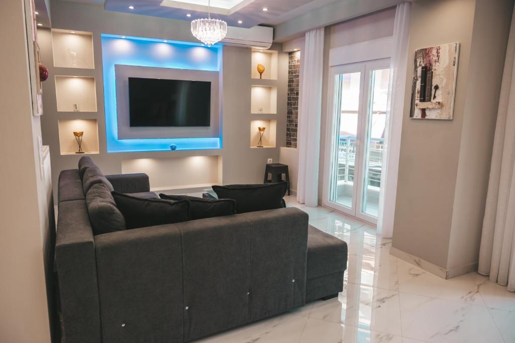 a living room with a couch and a flat screen tv at Lovely apartment with balcony in the city center in Katerini