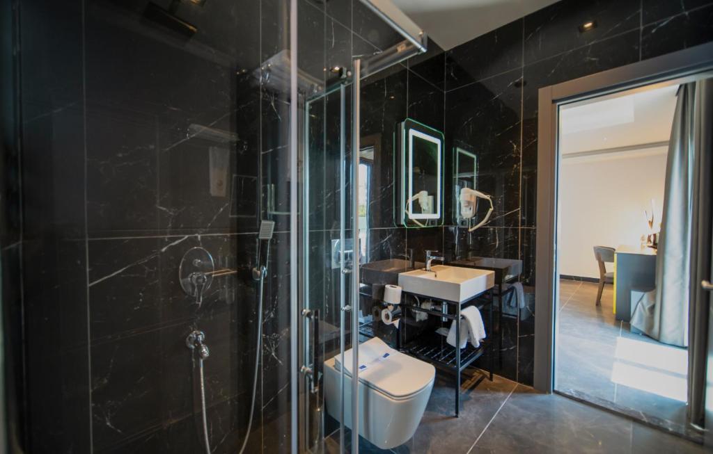 a bathroom with a sink and a shower and a toilet at Sea Palm Otel Yalıkavak in Yalıkavak