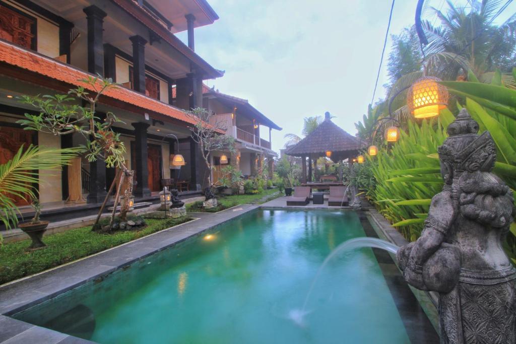 einen Pool im Innenhof eines Hauses mit einem Brunnen in der Unterkunft Surawan Bisma Ubud in Ubud