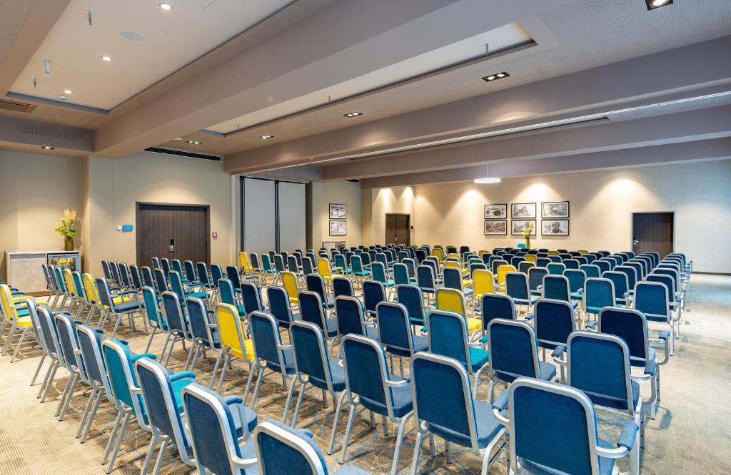 an empty conference room with chairs and a podium at Leonardo Hotel Augsburg in Augsburg