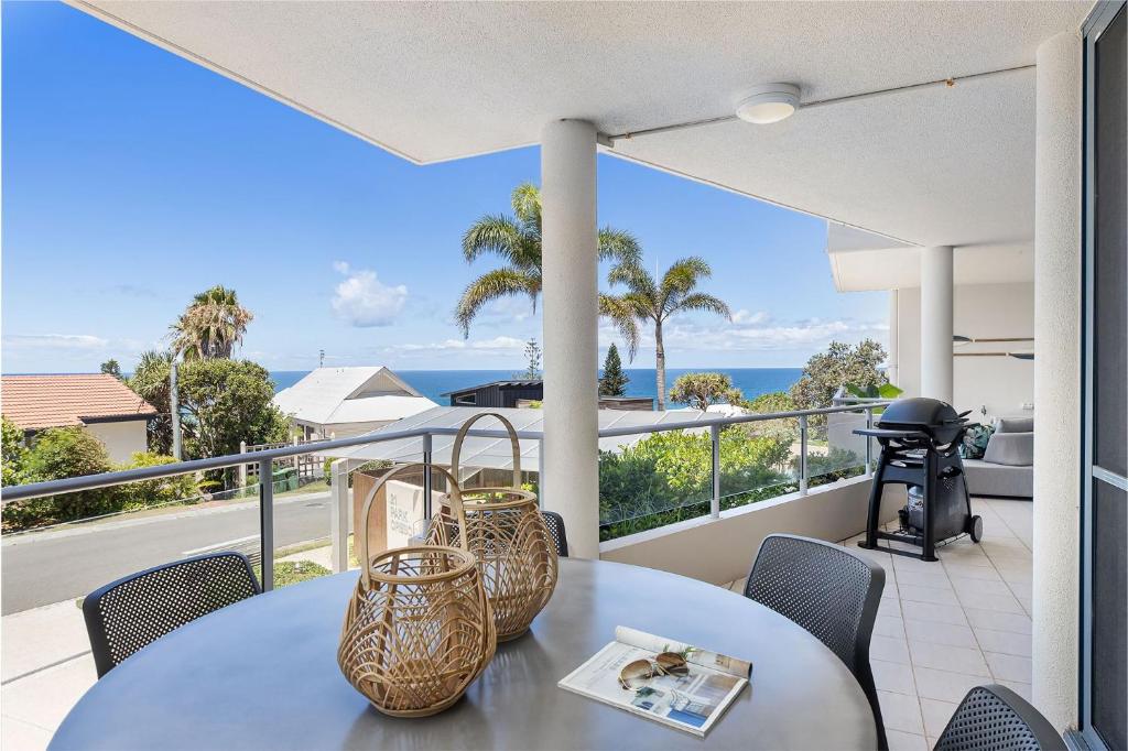 uma varanda com mesa e cadeiras e vista para o oceano em U2 Park Cres Modern & Stylish 2 bedroom apartment Close to Beach and Restaurants em Sunshine Beach