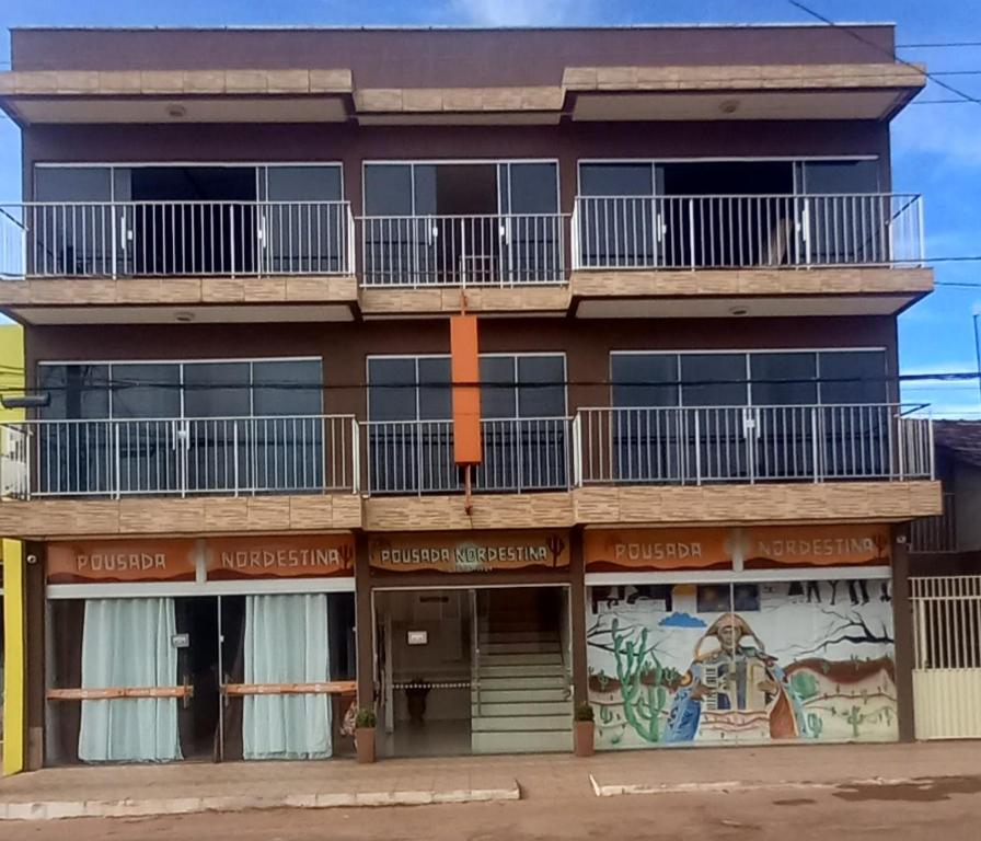 un edificio de apartamentos con balcones y un mural en Pousada Nordestina, en Riachão