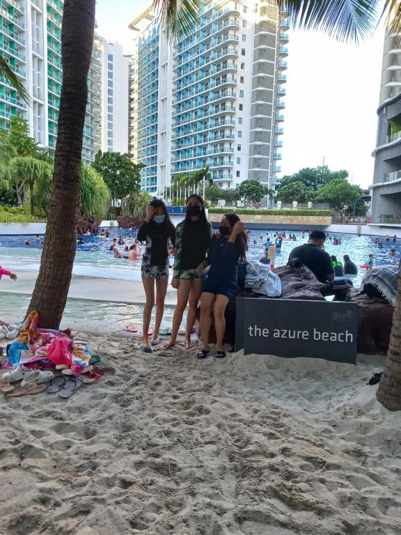 un grupo de personas de pie en la playa en Azure condotel staycation, en Manila