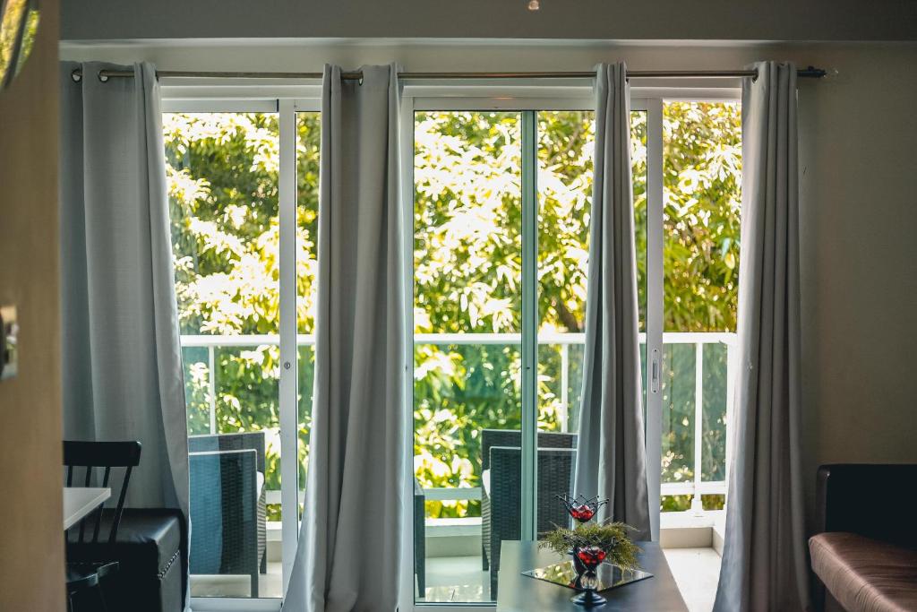 una ventana en una sala de estar con cortinas blancas en ARMONIA 408 APARTMENT IN GAZCUE, en Santo Domingo