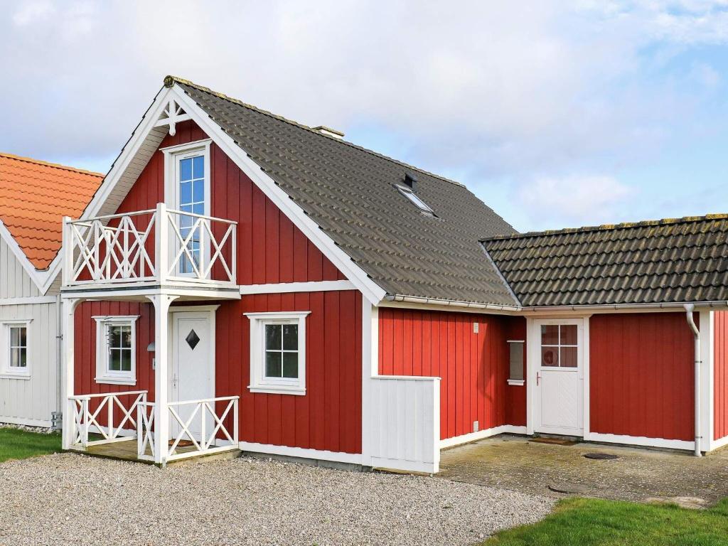 un granero rojo con puertas blancas y techo gris en 6 person holiday home in Brenderup Fyn, en Bro