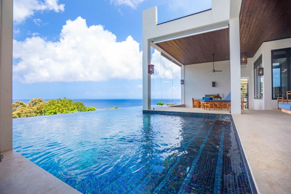 an infinity pool in a villa with a view of the ocean at Ocean Pearl home in Roatan