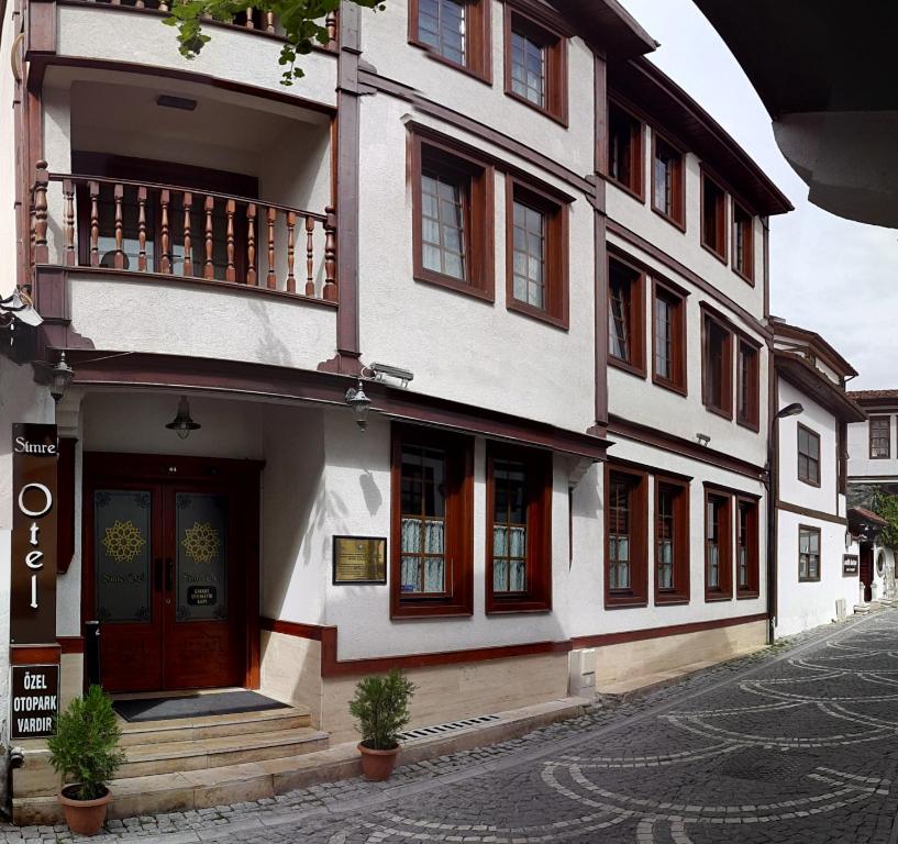 a white building with a balcony on a street at Simre Hotel in Amasya