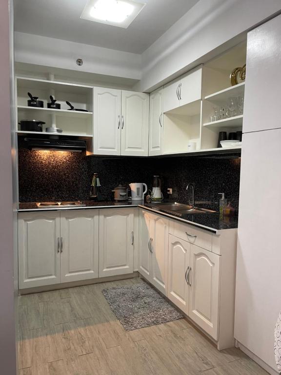 uma cozinha com armários brancos e bancadas pretas em Cozy 1 bedroom condo with pool. em Mandaue City