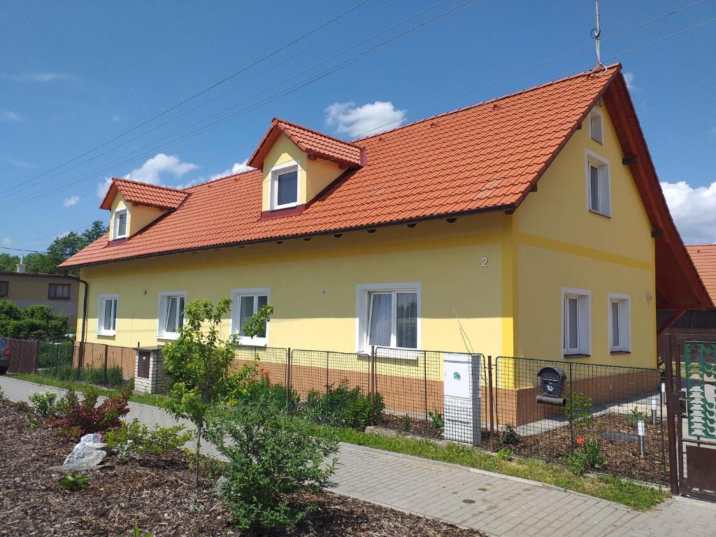 una casa amarilla con techo naranja en Ubytování ve Starém Dvoře, en Třemošnice